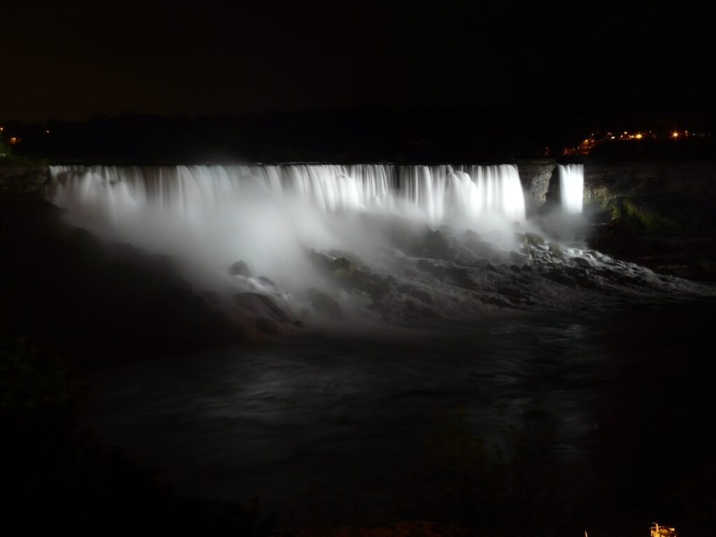 Niagara Falls at night with the white water and black rocks