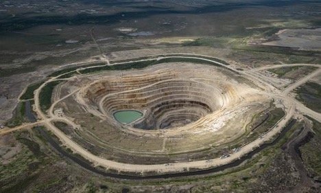 Aerial photo of the Victor Mine which looks like a large roughly circular pit with a small lake in the center