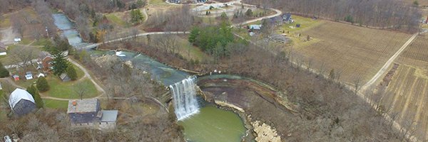 Twenty Mile Creek and Lower Ball's Falls. Aerial photo showing river flowing over waterfall and into pond. Surrounding farms are also pictured.