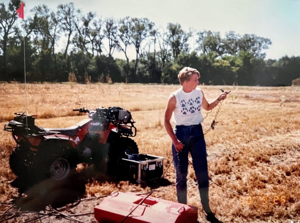 Woman standing in a feild with equipment behind her