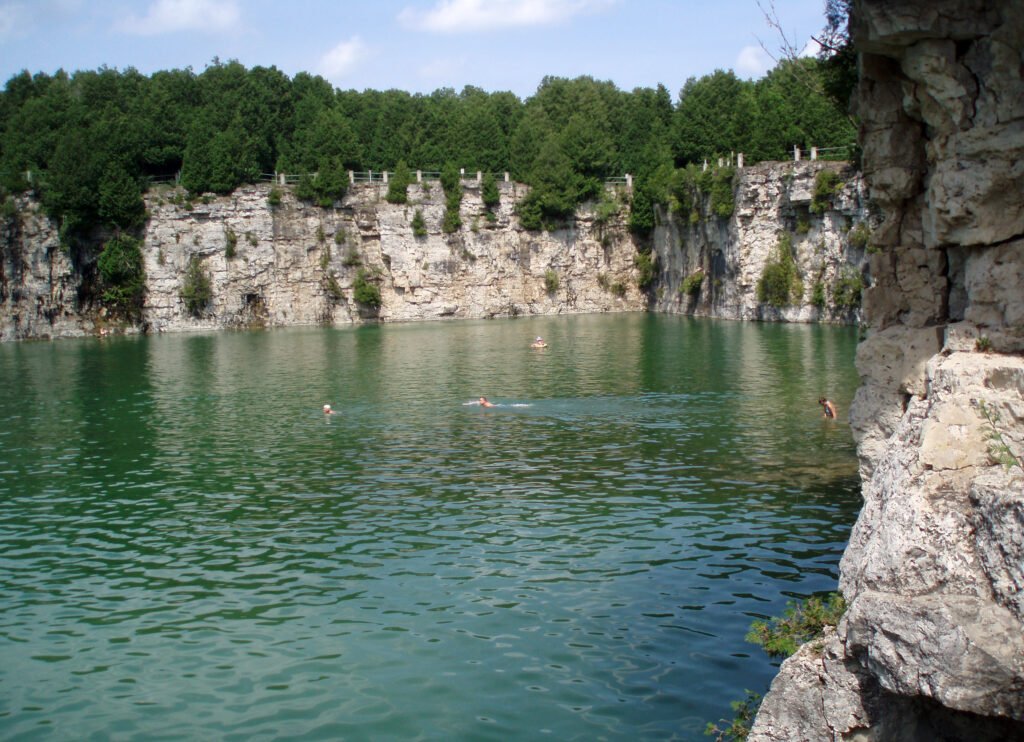 Large limestone cliffs surrounding blue water at the Elora Quarry