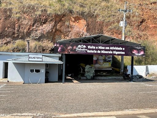 Building in front of a large red-coloured rock face.