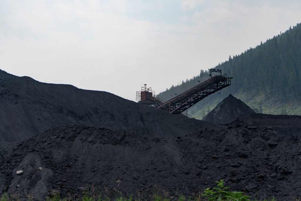 A mining machine on top of a large hill of soil.