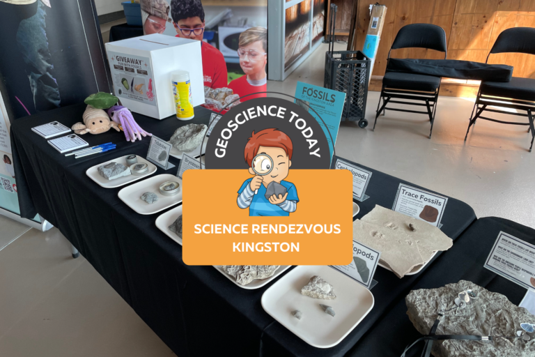 The APGOEF table at Science Rendezvous with fossils and stuffed animals. On top of the image text reads "Geoscience today: Science Rendezvous Kingston"