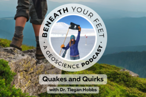 Dr. Tiegan Hobbs stands on a snowy landscape holding a black flag with a skull on it. Text reads: Beneath Your Feet A Geoscience Podcast. Quakes and Quirks with Dr. Tiegan Hobbs